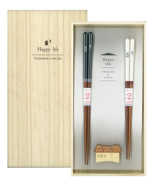 A gift set of chopsticks with rests, presented in a wooden box with a 'Happy Life' inscription. The set includes two pairs of chopsticks with a clear and dark finish, and two wooden rests.