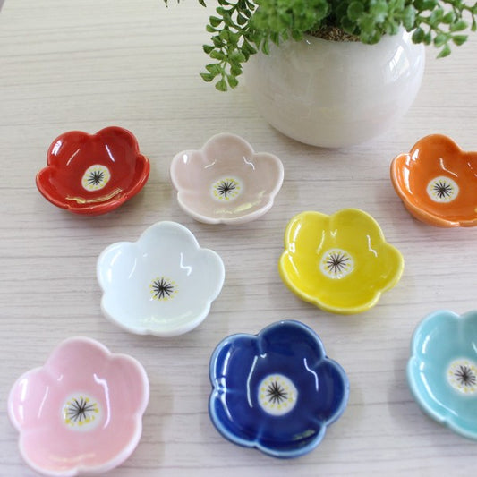 Colorful Hasami Ware flower chopstick rests displayed on a wooden table