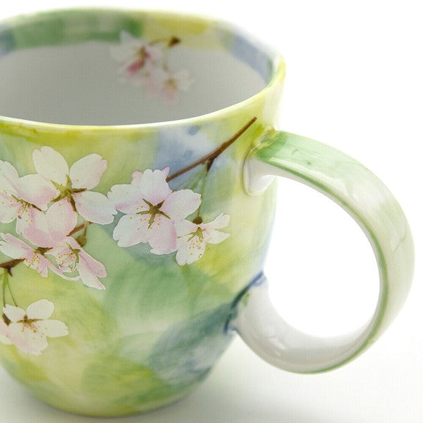 Close-up of cherry blossom print on greeen porcelain mug showing fine details