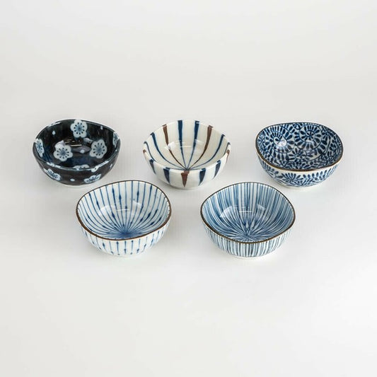 Five indigo-patterned Mino Ware plates displayed on table.