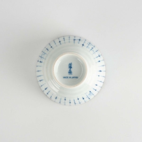 Bottom view of vertical striped porcelain teacup with unglazed foot and kiln mark