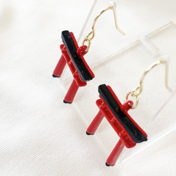 Close-up of three-dimensional torii gate earring design showing handcrafted details