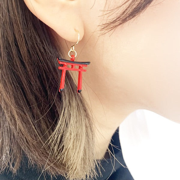 Model wearing red and black torii gate earrings, a unique Japanese statement accessory