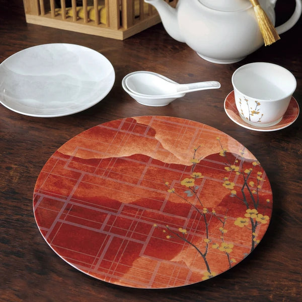 Japanese NIKKO porcelain plate in red and gold, arranged in a refined dining setting