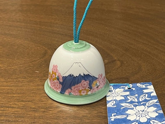 Detailed view of cherry blossoms against blue Fuji design on porcelain wind chime