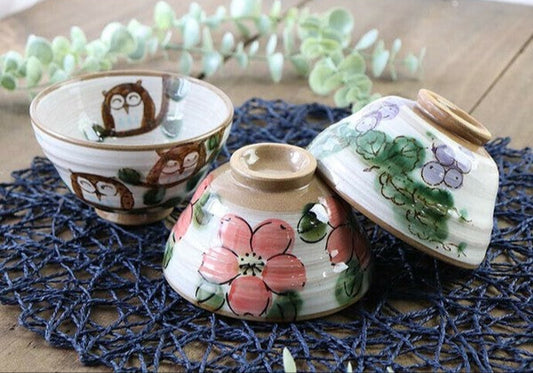 Set of three hand-painted Minoware rice bowls featuring owl, grape, and flower motifs, each with warm earthy tones