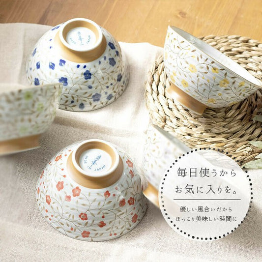 Set of three floral rice bowls in red, blue, and yellow, displayed together with soft pastel tones