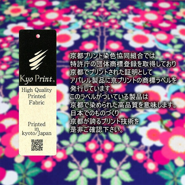 Fabric label with text and QR code against a colorful floral background.