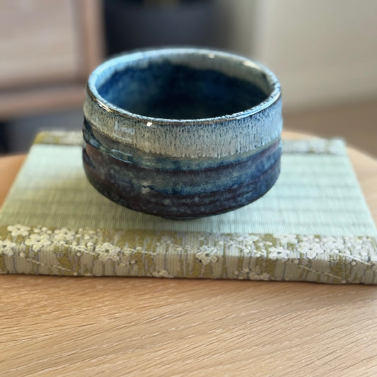 Handcrafted Japanese matcha bowl with soft blue-green glaze, ideal for tea time.