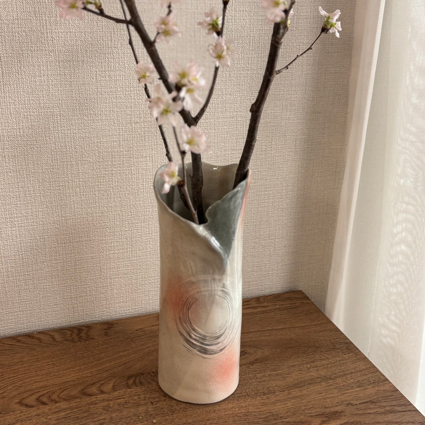 Close-up of ceramic vase showing white glaze with natural ash-gray accents