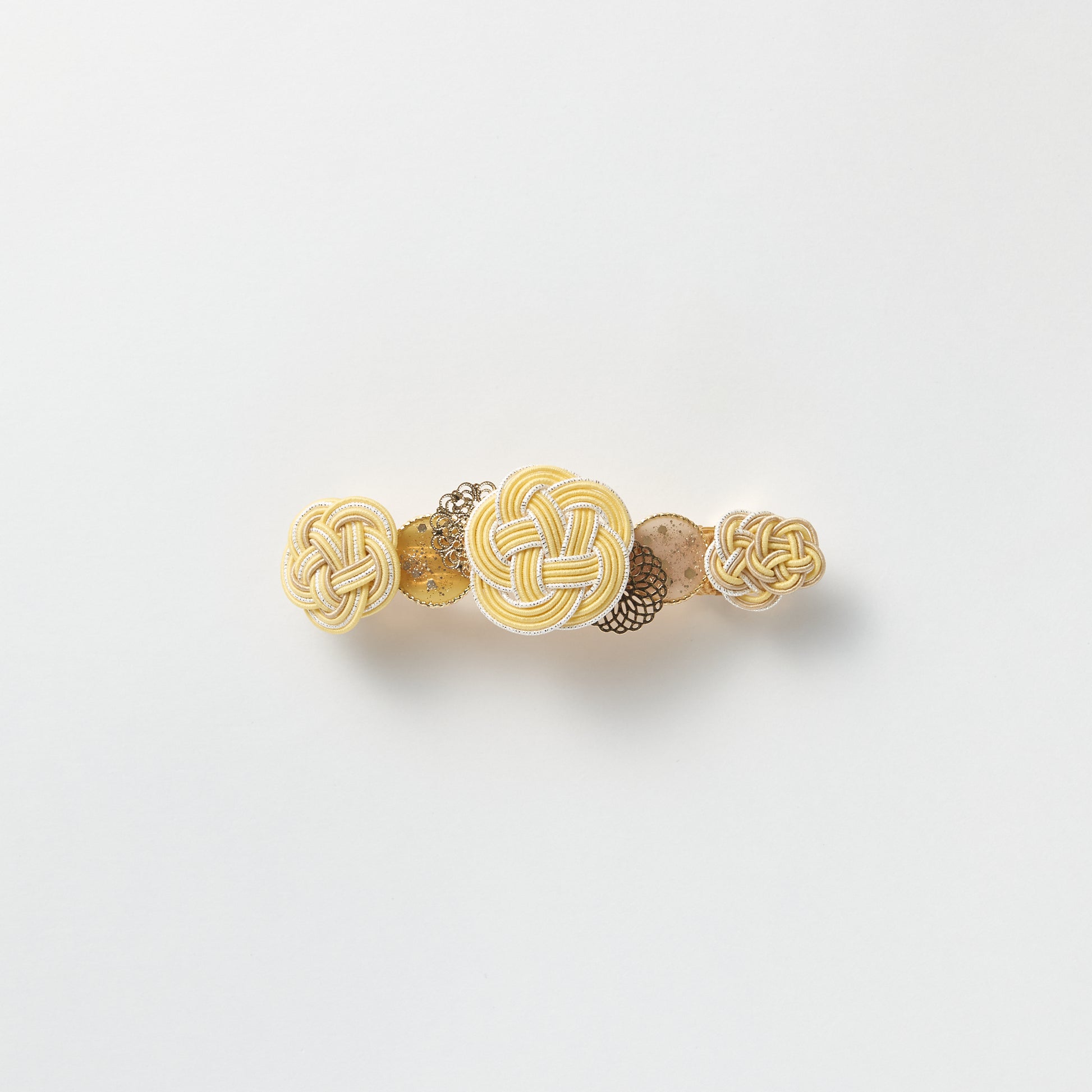Front view of handmade Plum Blossom Knot Barrette in yellow, featuring silk-wrapped mizuhiki knot