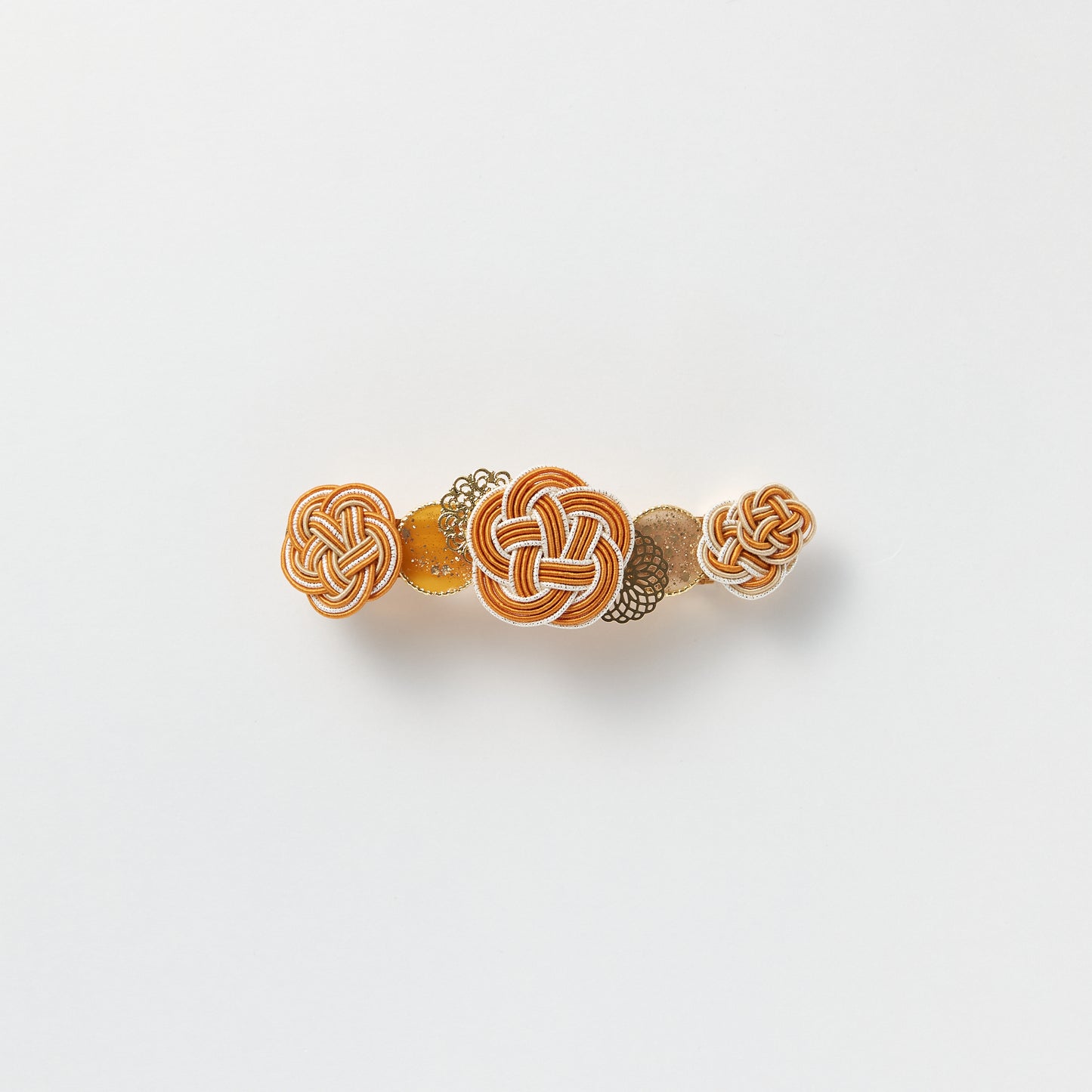 Front view of handmade Plum Blossom Knot Barrette in orange, featuring silk-wrapped mizuhiki knot