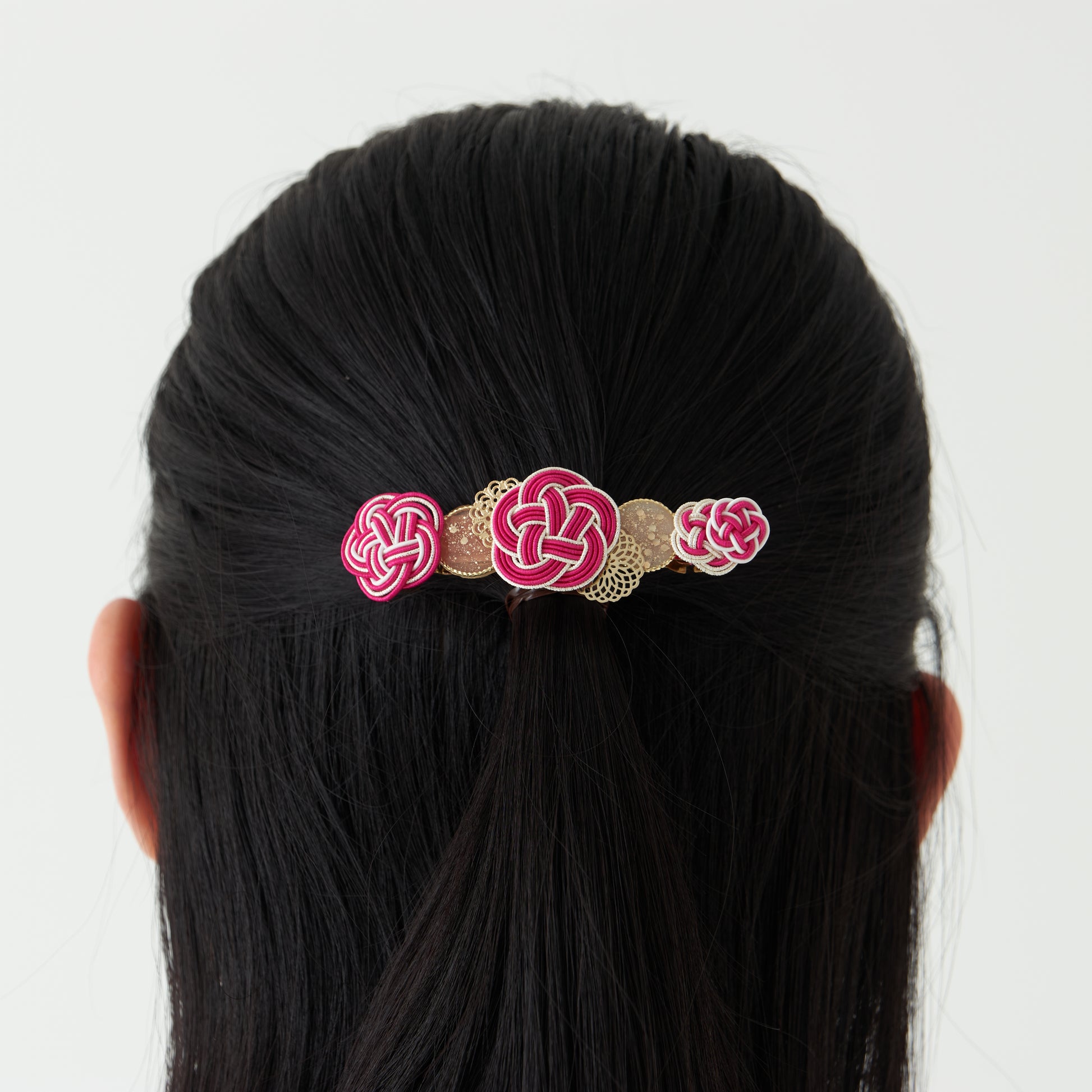 A model wearing the pink Japanese-style barrette with traditional mizuhiki knot in plum blossom design