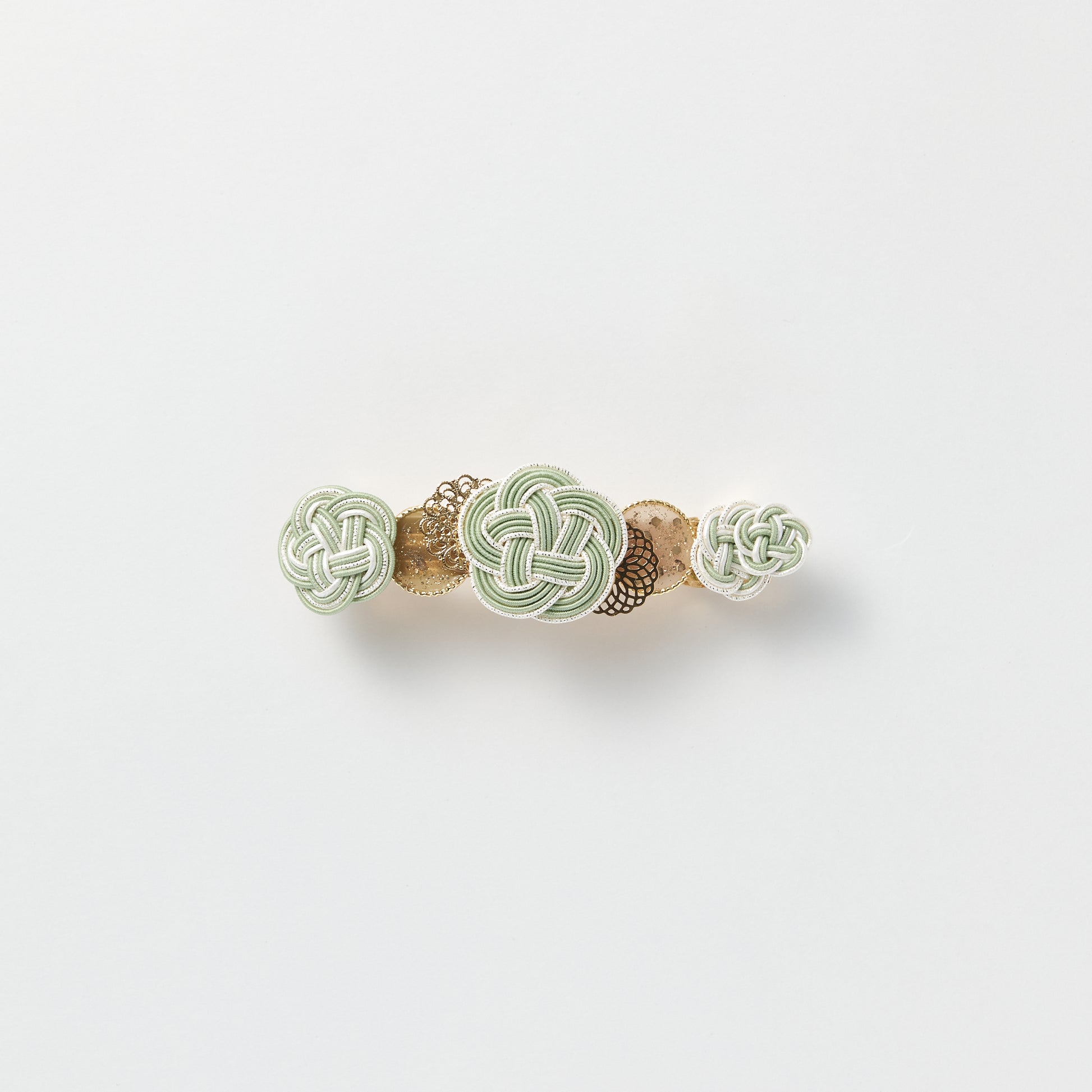Front view of handmade Plum Blossom Knot Barrette in green, featuring silk-wrapped mizuhiki knot