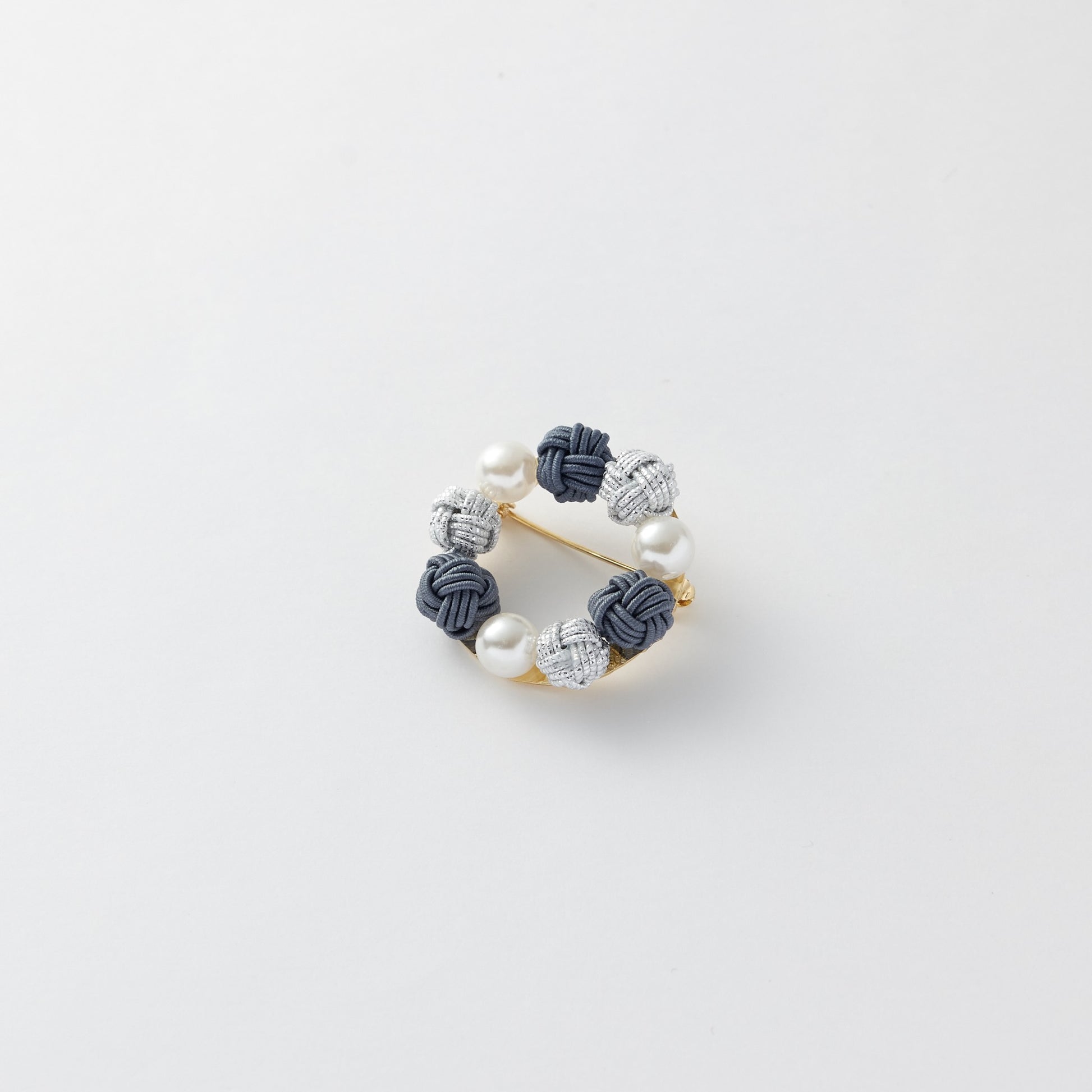 Close-up of Japanese mizuhiki knot brooch in circular design