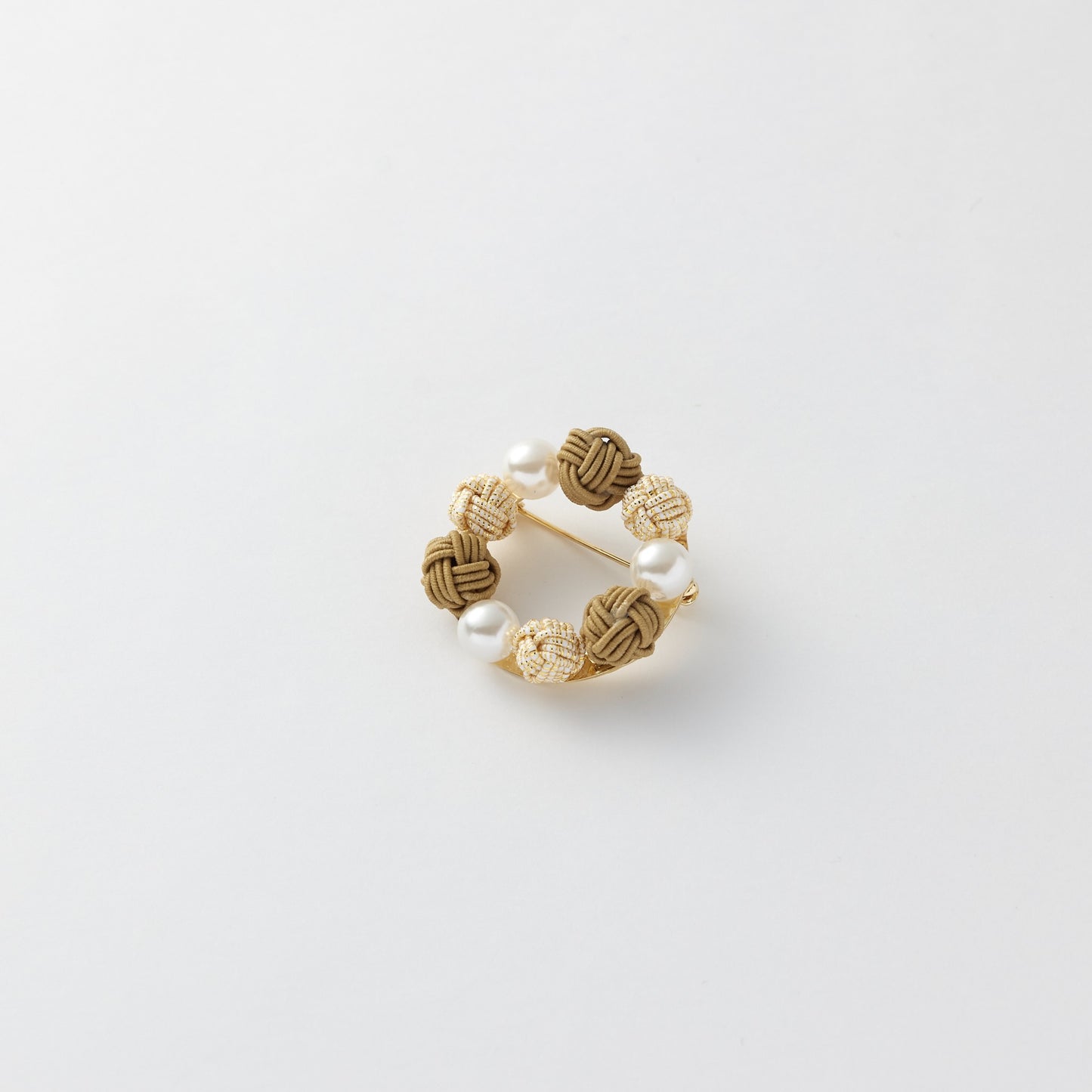 Close-up of Japanese mizuhiki knot brooch in circular design