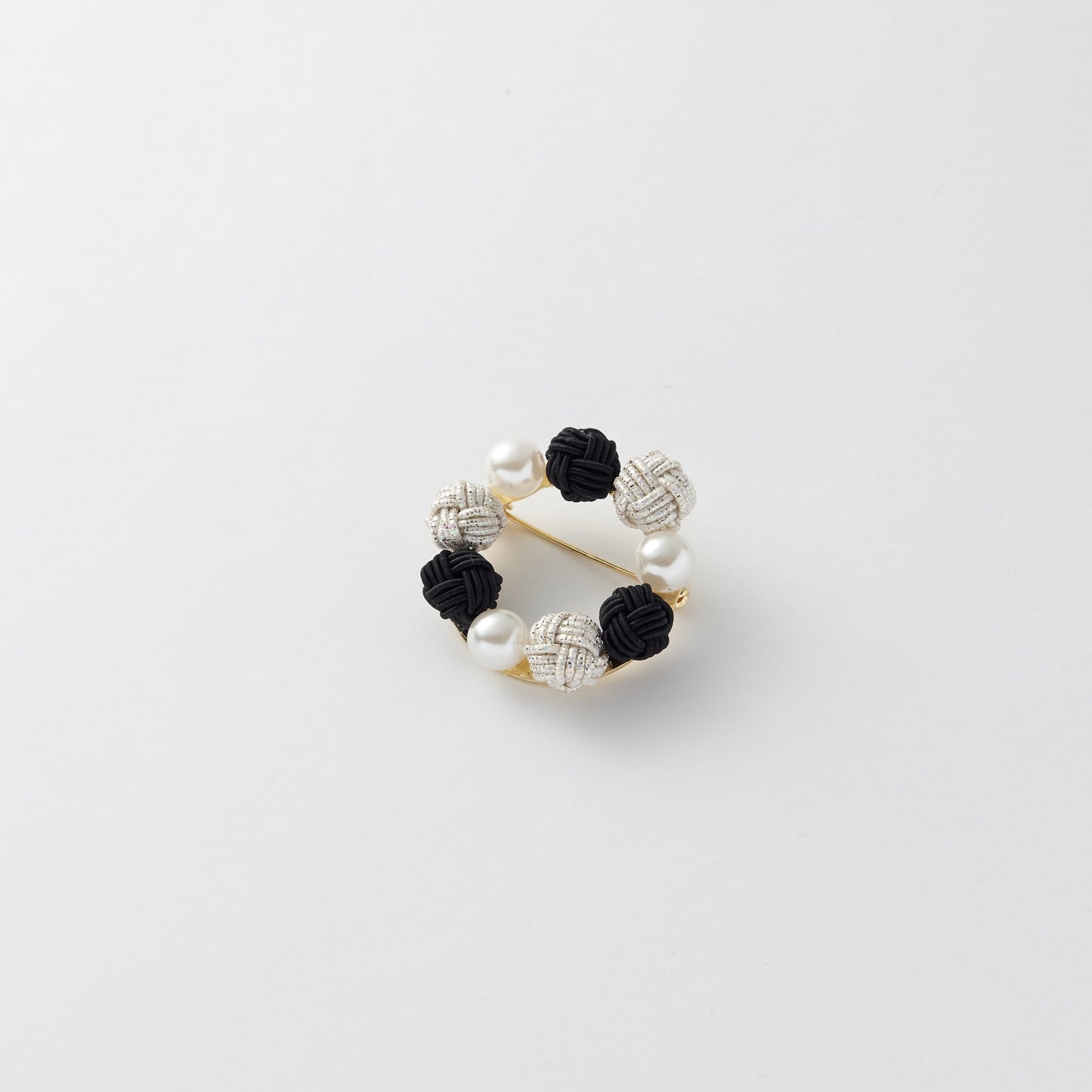 Close-up of Japanese mizuhiki knot brooch in circular design