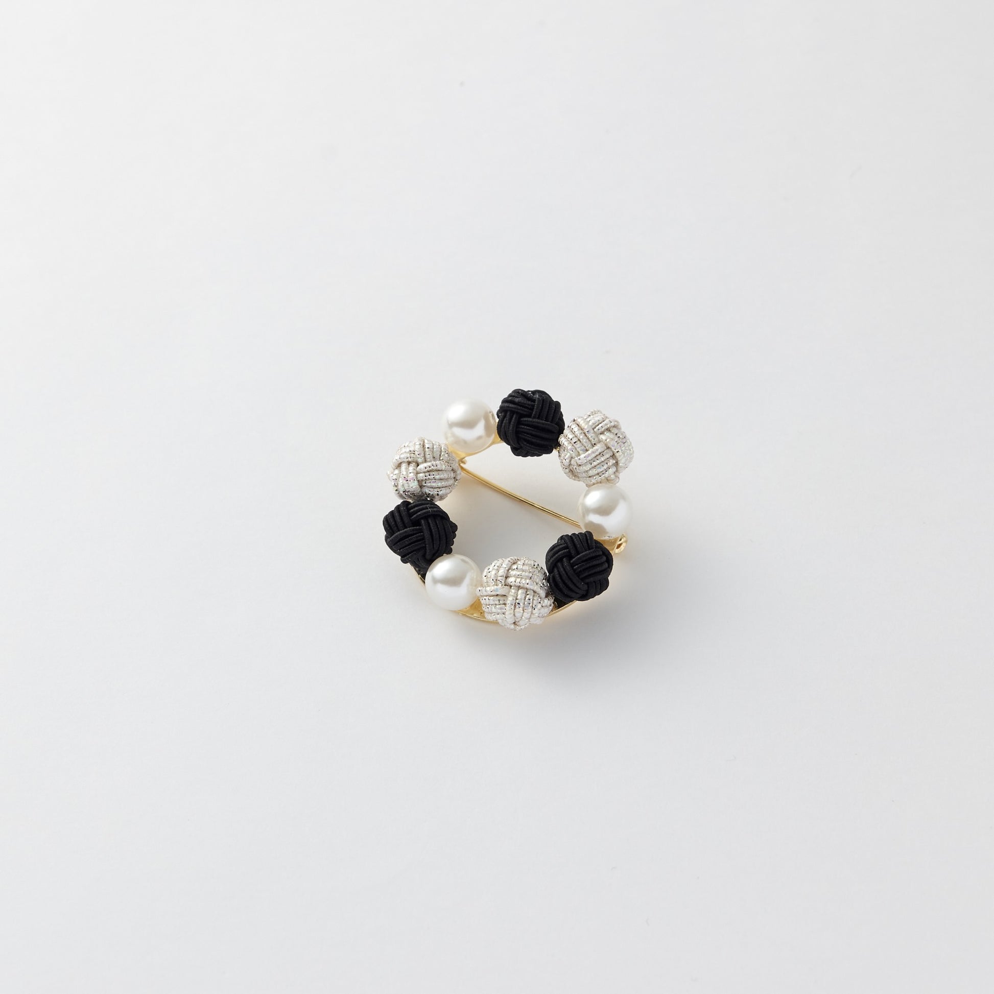 Close-up of Japanese mizuhiki knot brooch in circular design