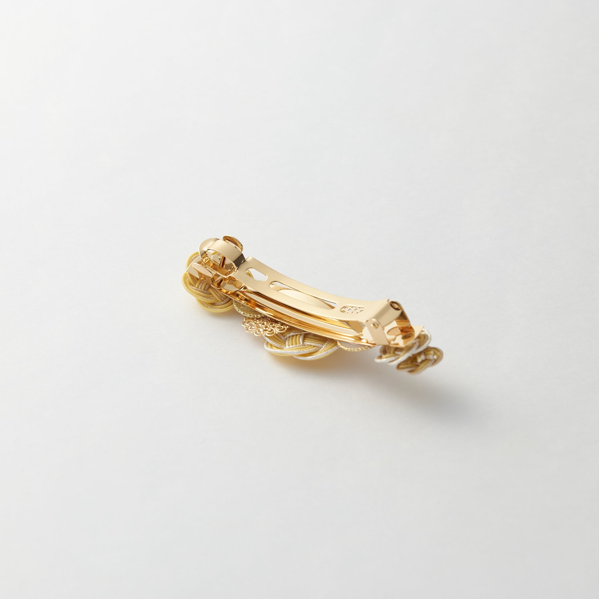 Reverse side of handmade Japanese hair accessory in yellow, showing clasp detail