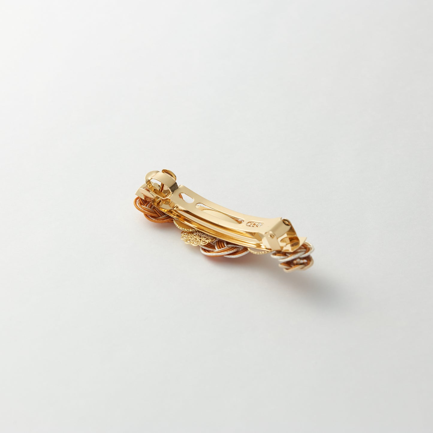 Reverse side of handmade Japanese hair accessory in orange, showing clasp detail