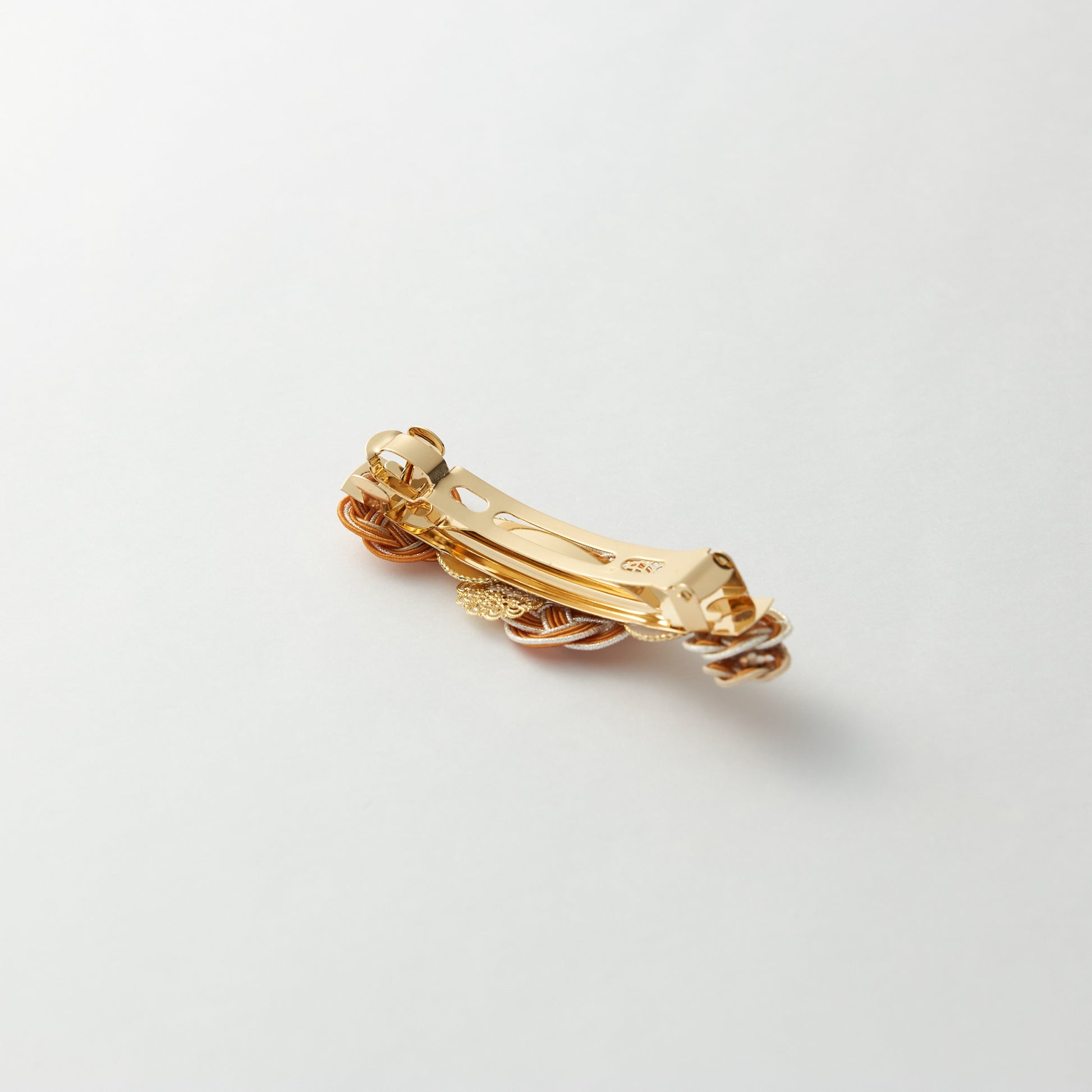 Reverse side of handmade Japanese hair accessory in orange, showing clasp detail