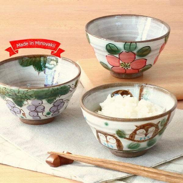 Set of three hand-painted Minoware rice bowls featuring owl, grape, and flower motifs, each with warm earthy tones