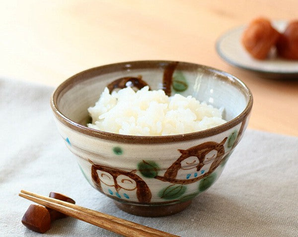 Minoware rice bowl with hand-painted owl design, filled with freshly cooked white rice, showing everyday use