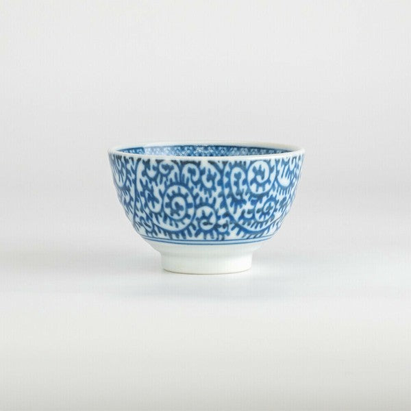 Side angle of Japanese porcelain teacup featuring traditional indigo scroll design
