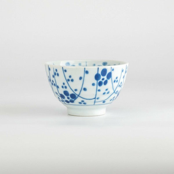 Side angle of Japanese porcelain teacup featuring scattered plum blossom design in blue