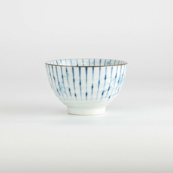Side angle of Japanese porcelain teacup featuring blue drip-style vertical stripe pattern