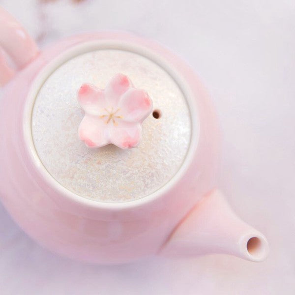 Close-up of sakura blossom lid on pink teapot