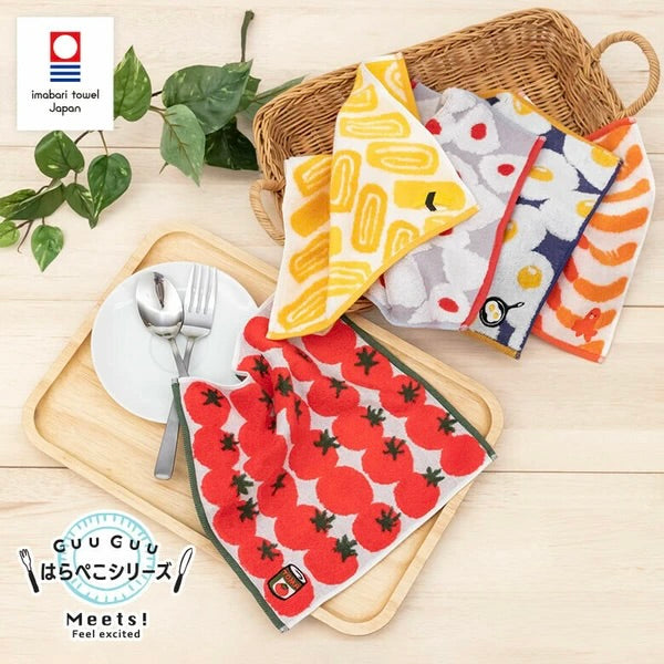 Jacquard towel handkerchief from the GuuGuu series with soft, fluffy texture and playful design, displayed flat on a basket.

