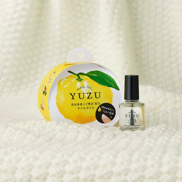 Yuzu nail oil packaging and bottle on a textured white background