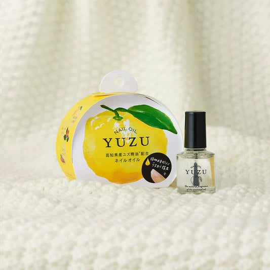 Yuzu nail oil packaging and bottle on a textured white background
