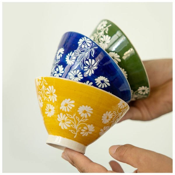 Three colourful Japanese ceramic rice bowls with delicate white daisy flowers