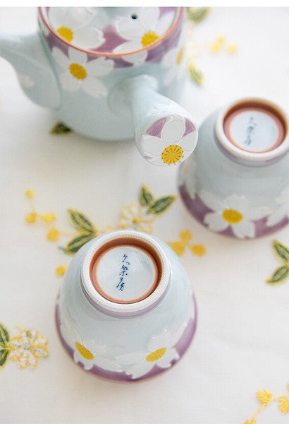 Detail of floral pattern on teapot handle with soft blue and purple background
