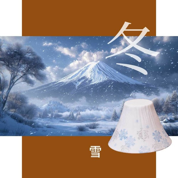 Snowy mountain landscape with a COFIL coffee dripper featuring snowflake patterns on a brown and white background.