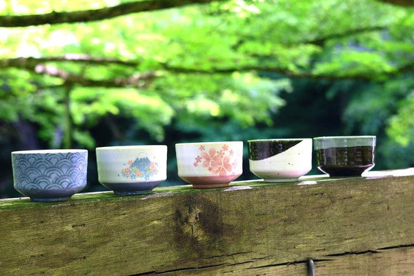 Collection of five Mino ware matcha bowls in assorted traditional patterns