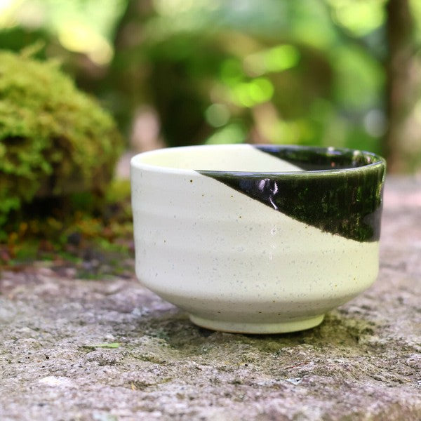 Mino ware matcha bowl in oribe style design, displayed outdoors