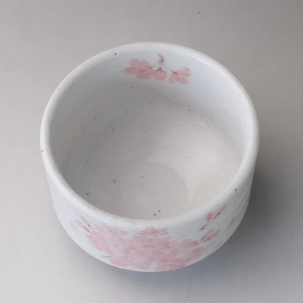 Top view of Japanese Mino ware matcha bowl with smooth white interior and sakura design