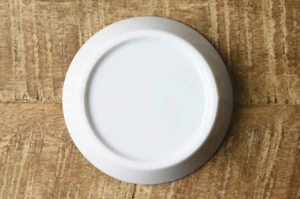 Back view of white porcelain dipping plate with sauce revealing a Mount Fuji design