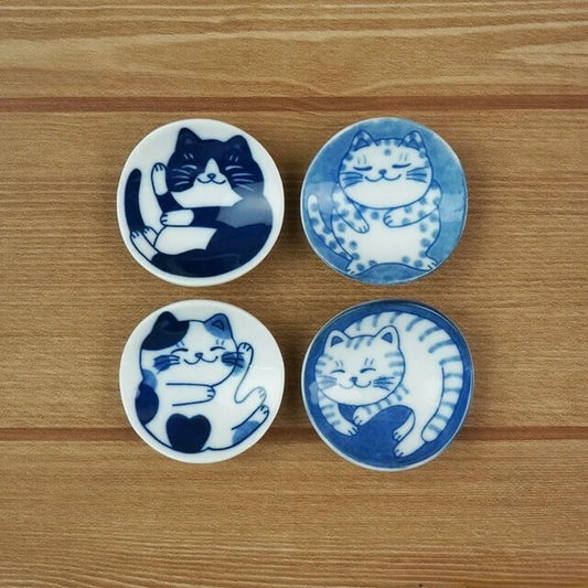 Set of four round ceramic chopstick rests from the Nekochigura collection, featuring charming cat designs with unique expressions in traditional Japanese Mino ware