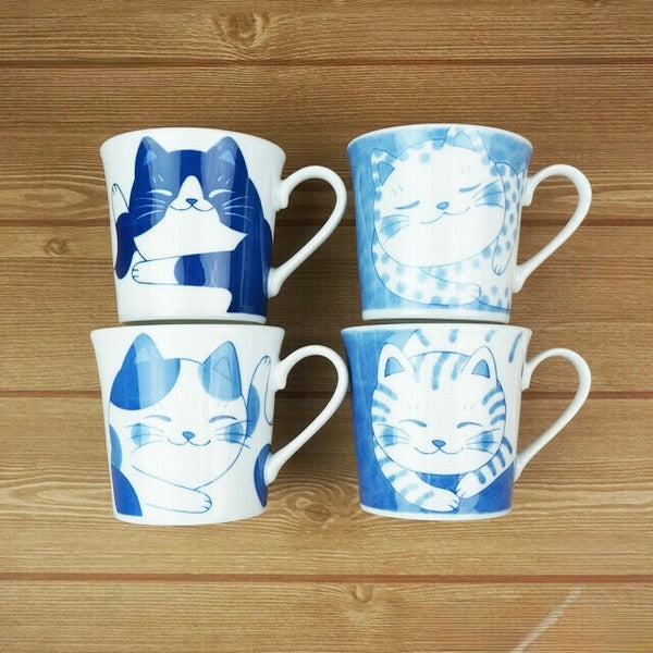 Set of four Japanese Mino ware mugs with unique blue-and-white cat illustrations

