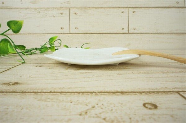 Side view of white Musubi plate with raised musubi design