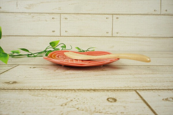 Side-vew of red Musubi plate with raised musubi design