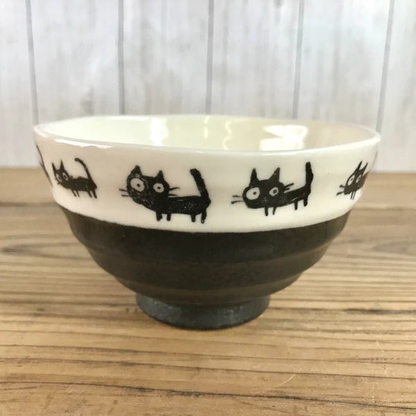 Close-up of black cat motif on Japanese rice bowl, highlighting the detailed artwork.

