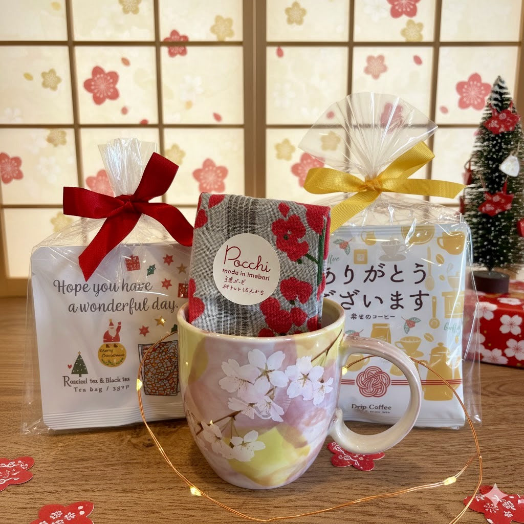 Tea set with cherry blossom mug, tea bags, and decorative items on a wooden surface.