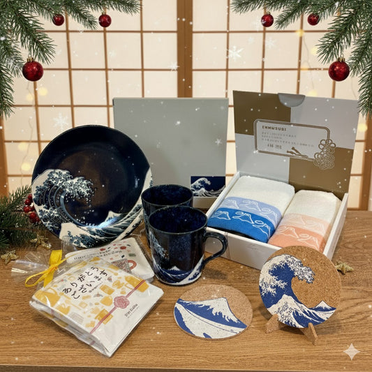 Set of ceramic items including mugs, plates, and coasters with wave design on a wooden surface.