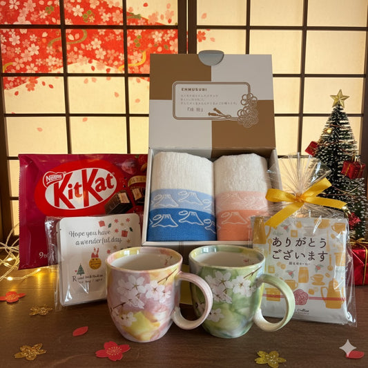 Gift set with mugs, KitKat chocolate, and other items against a decorative background
